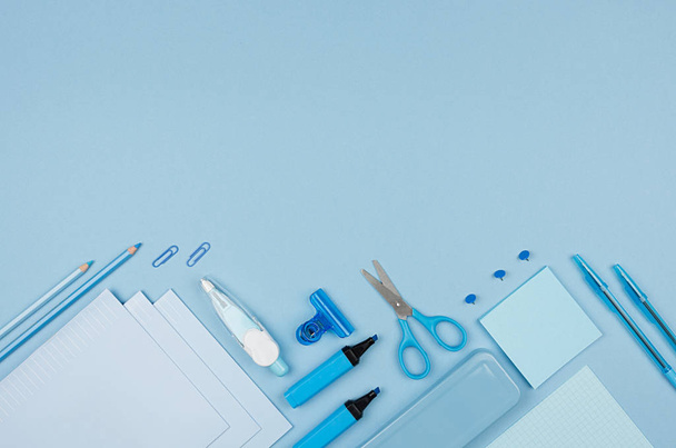 Different office supply on blue color background, top view, copy space, horizontal. - Foto, Imagen