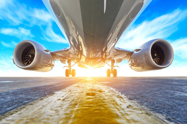Avión en el estacionamiento del delantal del aeropuerto, hdr vista inferior de motores, fuselaje y alas. Sobre el fondo del cielo nubes y luz solar brillante
 - Foto, Imagen