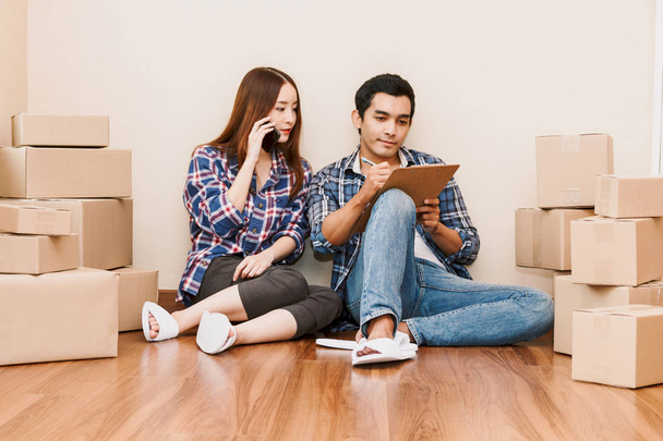 Lista de verificación de pareja joven con caja de cartón en casa - Negocios en línea y concepto de entrega
 - Foto, imagen
