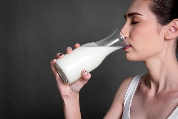 Женщина держит стакан свежего молока.
 - Фото, изображение