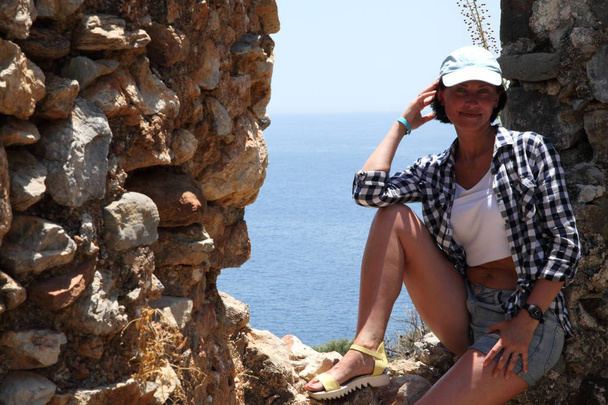 Näkymä Alanyan satamaan Alanyan niemimaalta. Turkin Rivieralla. Kaunis tyttö poseeraa kameran taustalla meren. Malli poseeraa rannalla kesäpäivänä
. - Valokuva, kuva