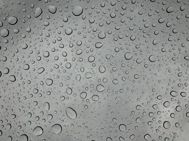 Gocce di pioggia sulla superficie degli occhiali finestra con sfondo nuvoloso Modello naturale di gocce di pioggia isolate su sfondo nuvoloso
  - Foto, immagini