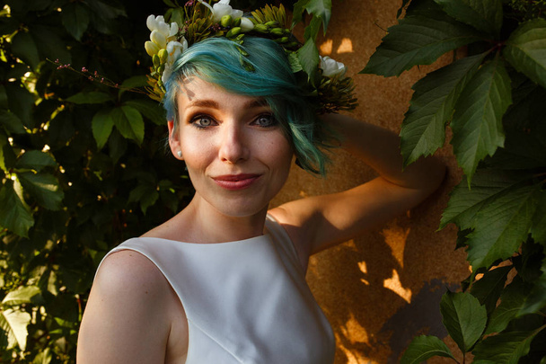 Portrait of a beautiful bride with blue hair and a wreath of real flowers. Wedding day. .A beautiful bride portrait in the forest. - Zdjęcie, obraz