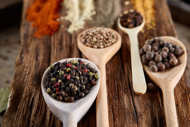 Row of wooden spoons with spices on vintage background, diminishing perspective, close-up, selective focus - Φωτογραφία, εικόνα