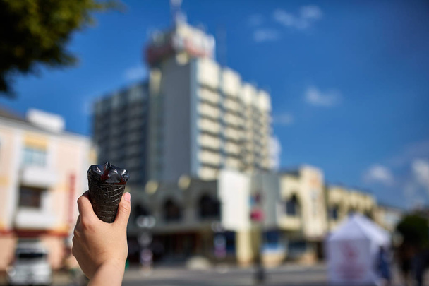 A first person view, girl walking along the road with an ice cream in her hands, shallow depth of field. - 写真・画像