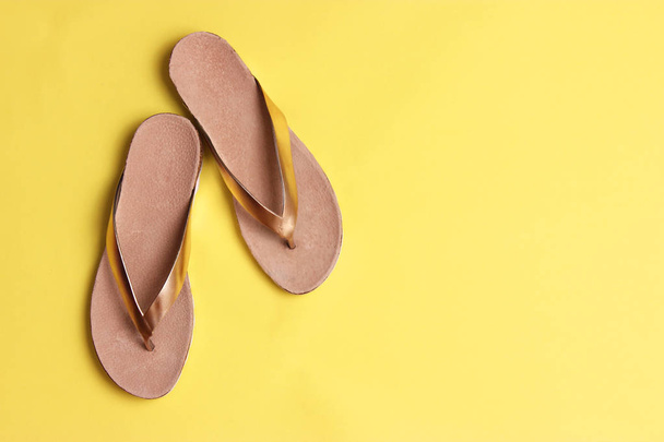 vrouwelijke slippers boven op een gekleurde achtergrond weergeven. minimalisme, Damesschoenen. - Foto, afbeelding