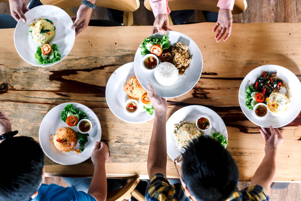 Vista superior de pessoas jantando juntas na mesa de madeira
 - Foto, Imagem