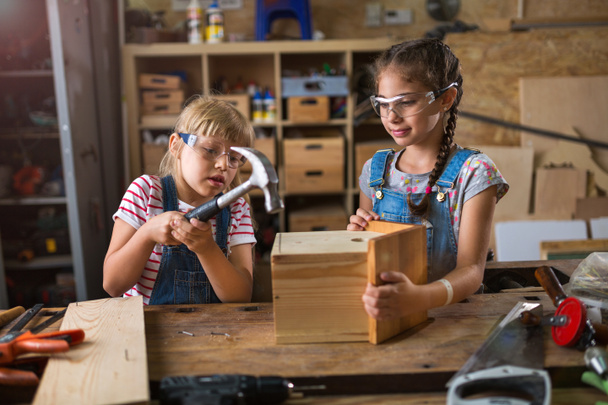 Dvě mladé dívky dělají ze dřeva v dílně - Fotografie, Obrázek