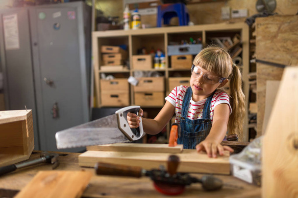 Młoda dziewczyna robi stolarki w warsztacie - Zdjęcie, obraz