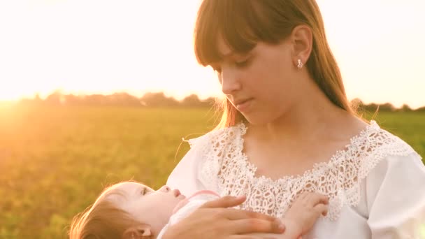 junge Mutter wiegt ihr Baby bei Sonnenuntergang in Zeitlupe - Filmmaterial, Video
