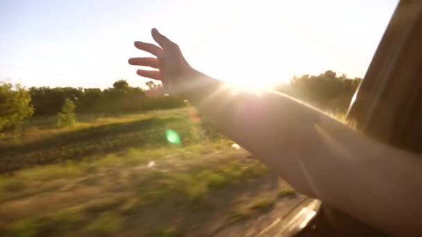 Meisje zwaaien van de auto venster en vangsten zon, slow-motion - Video