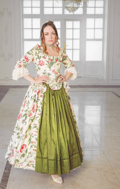 美しい女性で長い緑の中世のドレスでホール - 写真・画像