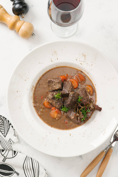 Top view of stewed beef with carrot served in white plate - Photo, Image