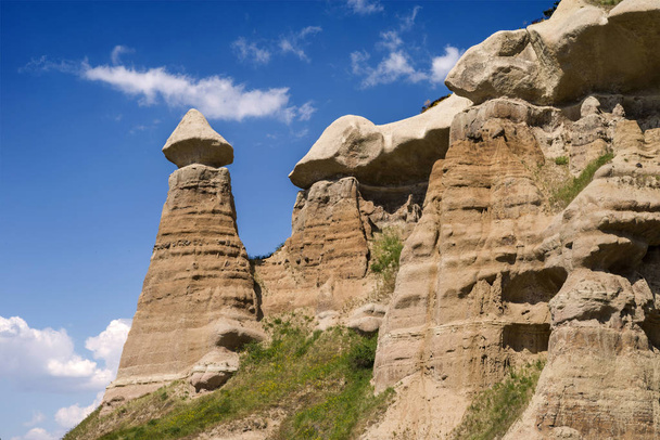 Formacje piaskowca w dolinie niedaleko Uchisar w słoneczny dzień. Kapadocja, Turcja. - Zdjęcie, obraz