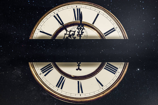 relógio velho com algarismos romanos em um contexto de um céu estrelado com um lugar para o texto no centro
 - Foto, Imagem