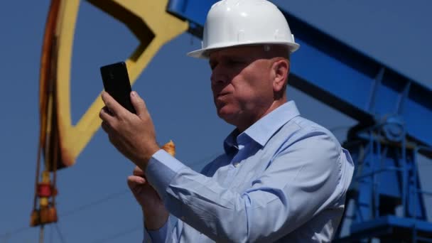 Oil Industry Engineer Inspecting and Eating Snack While Reading Phone Messages - Кадры, видео