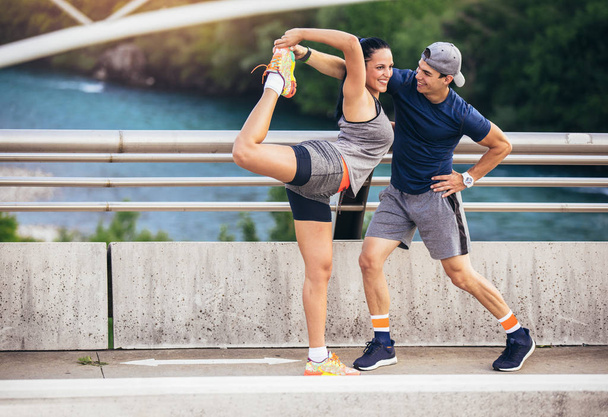 fitness, sport, people and lifestyle concept - man and woman exercising outdoors - Φωτογραφία, εικόνα