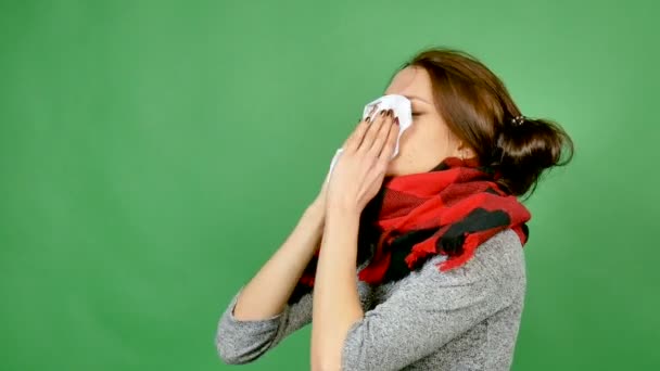 Nuori, viehättävä ruskeaverikkö on sairas. Tyttö puhdistaa nenänsä, hänellä on vuotava nenä, kuume ja muut virusinfektion oireet.
 - Materiaali, video
