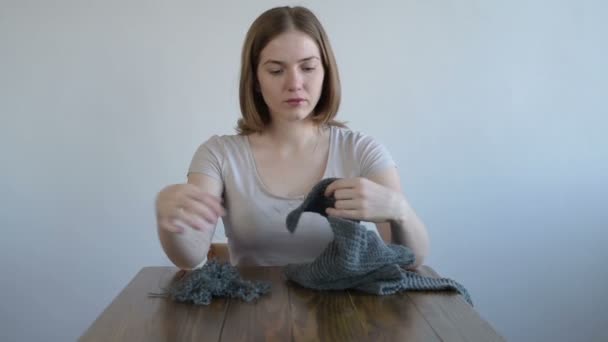 Mujer desentrañando el tejido gris
 - Imágenes, Vídeo