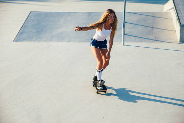 Beautiful skater girl lifestyle moments in a skatepark - Фото, зображення