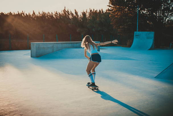 Beautiful skater girl lifestyle moments in a skatepark - 写真・画像