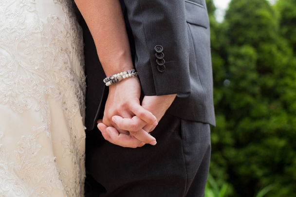 Νύφη και ο γαμπρός έχουν χέρια σε εξωτερική γαμήλια τελετή - Φωτογραφία, εικόνα