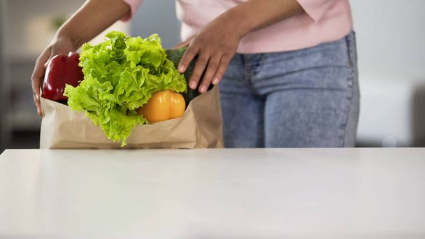Lady taking vegetables from grocery bag, healthy eating, organic food, diet - Fotoğraf, Görsel