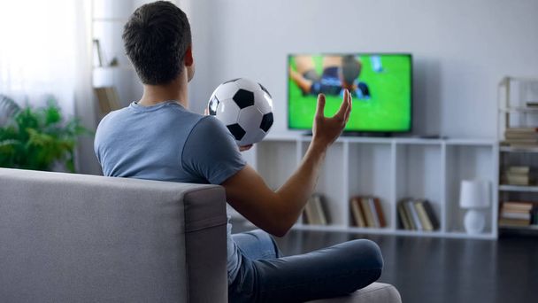 Supporter of soccer team watching game on tv home, unhappy with match result - Foto, imagen