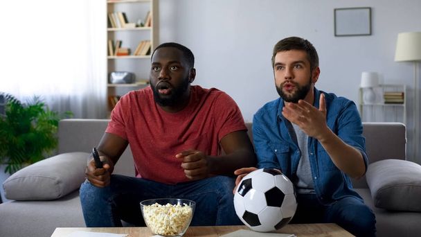 Multiethnic guys watching football match, frustrated by defeat of favourite team - Valokuva, kuva