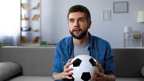 Excited man nervously watching football match on tv at home, end of first half - Photo, Image