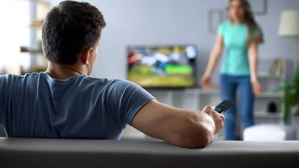 Woman quarreling, man watching football match, ignoring conflict, relationship - Foto, imagen