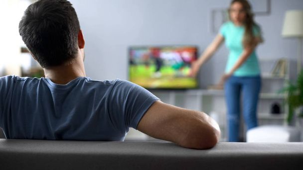 Man watching football match ignoring conflict with woman, crisis in relations - Photo, Image