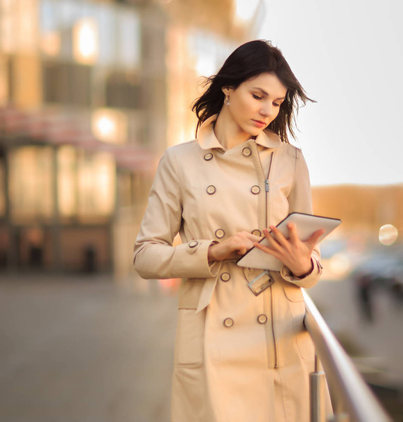 Business woman with a digital tablet on the background of a modern office building - Foto, imagen