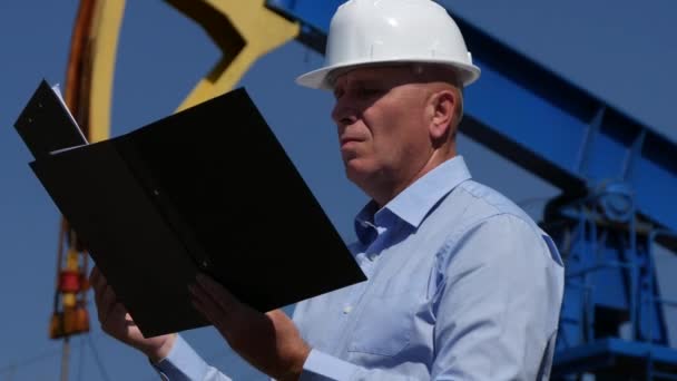 Oil Company Manager Supervise Rig Installations Check Files and Clipboard Pages - Materiał filmowy, wideo