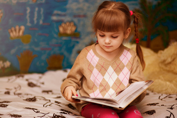 Veselá holčička číst knihu v posteli. Koncept děti znalostí - Fotografie, Obrázek