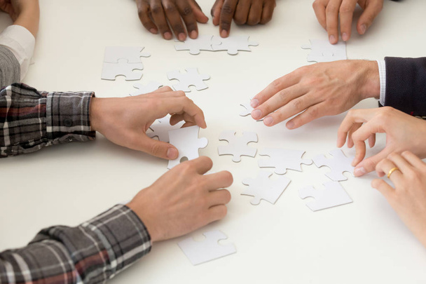 Diversi team di lavoro assemblare puzzle in attività di team building
 - Foto, immagini