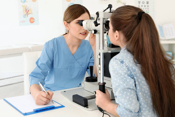 Ophthalmologist examining little girl in clinic - Фото, зображення