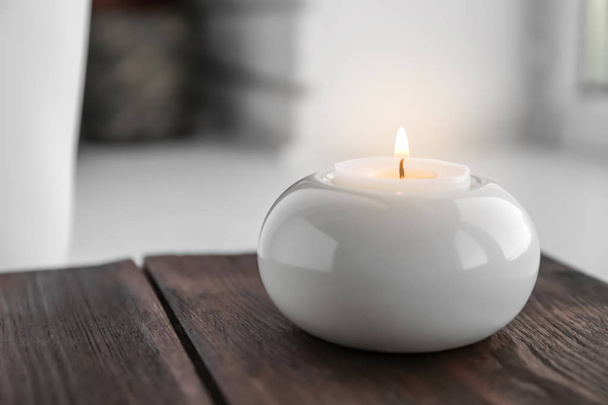Beautiful burning wax candle in holder on table - Foto, afbeelding