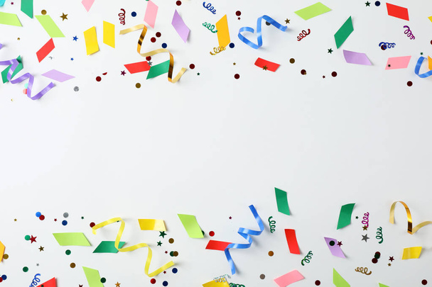 Colorful confetti and streamers on white background, top view - Фото, зображення