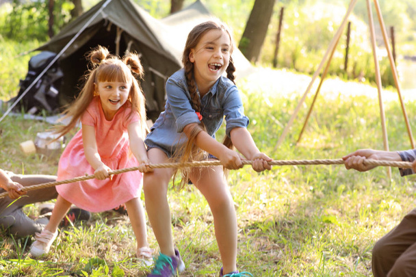 Little children pulling rope outdoors. Summer camp - Zdjęcie, obraz