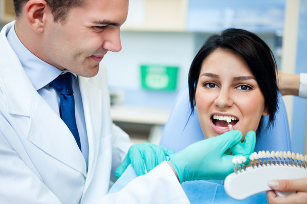 Dentist examining a whiteness of teeth of a patient - Фото, зображення