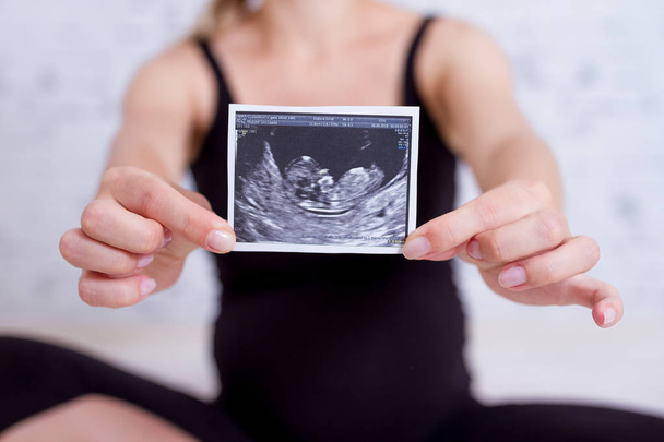 Κοντινό πλάνο Γυναίκα κοιτάζοντας usg φωτογραφίες από το μικρό μωρό - Φωτογραφία, εικόνα