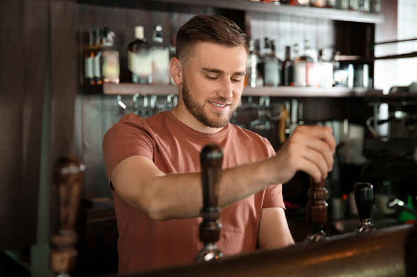 Barman pracujący w stuknij piwo w pubie - Zdjęcie, obraz