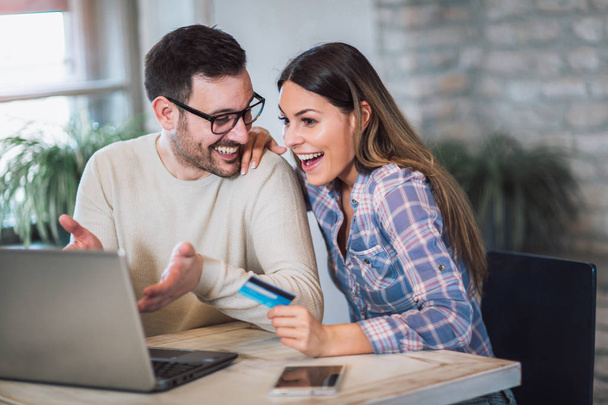 Lächelndes Paar mit digitalem Tablet und Kreditkarte zu Hause - Foto, Bild