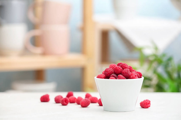 Bowl with ripe aromatic raspberries on table - Фото, зображення