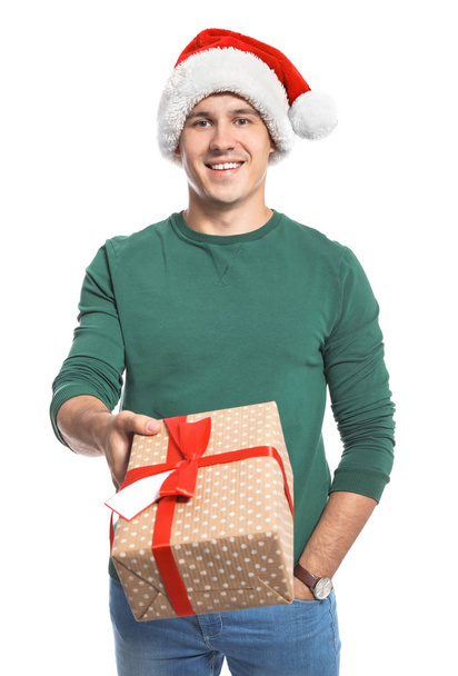 Young man with Christmas gift on white background - Фото, изображение