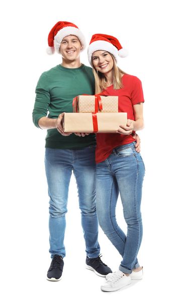 Young couple with Christmas gifts on white background - Foto, imagen
