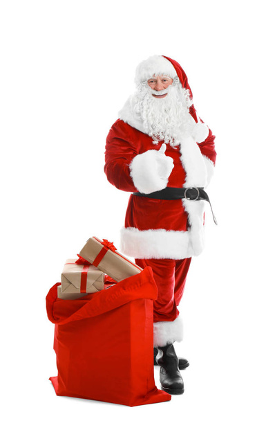 Настоящий Санта-Клаус с красной сумкой, полной подарков на белом фоне
 - Фото, изображение
