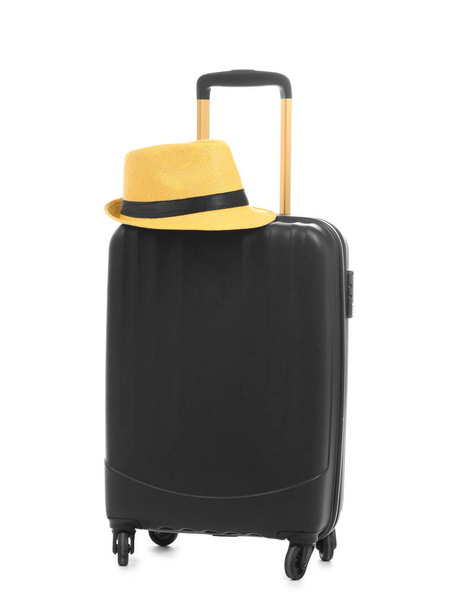 Black suitcase and hat packed for journey on white background - Photo, Image