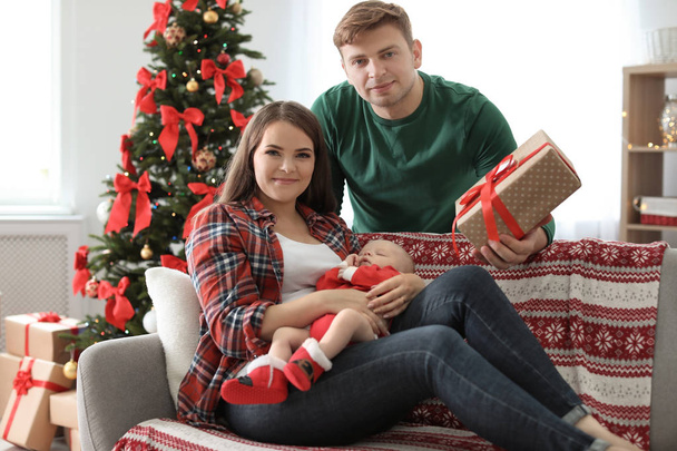 Happy couple with baby celebrating Christmas together at home - Foto, imagen